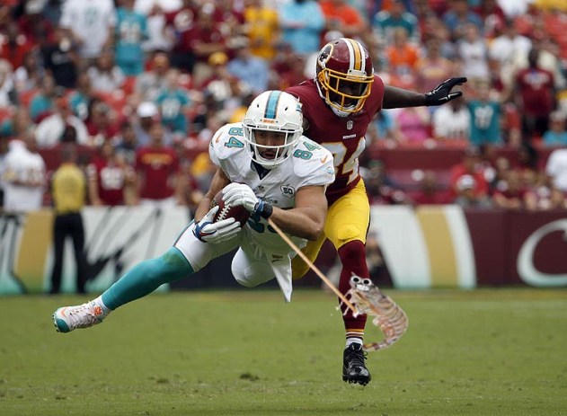 Miami Dolphins tight end Jordan Cameron (84) catches a pass for a first down in front of Washington Redskins free safety Trenton Robinson (34) during the second half of an NFL football game Sunday, Sept. 13, 2015, in Landover, Md. (AP Photo/Evan Vucci)